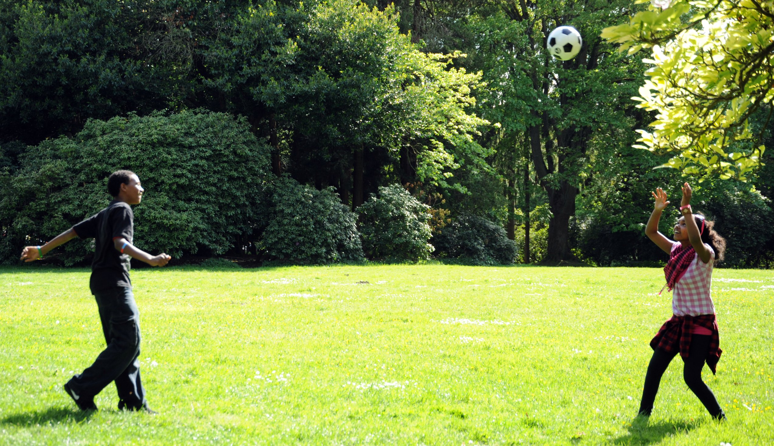 Two children playing soccer together.